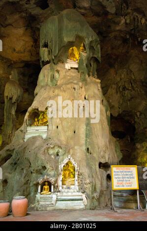 Thaïlande: Images de Bouddha dans les niches de Tham Khao Luang, Phetchaburi. Tham Khao Luang est une grande grotte composée de trois chambres reliées et se distingue par de nombreuses stalactites suspendues et des images de Bouddha, y compris un phra non ou Bouddha couché. La principale image de bronze a été moulée sur les ordres du roi Chulalongkorn (Rama V) et dédiée à ses illustres prédécesseurs, les Rois Rama III et Rama IV Il y a une ouverture naturelle dans le plafond de la deuxième chambre principale, par laquelle la lumière du jour éclaire les images à l'intérieur. Banque D'Images