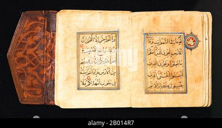 Moyen-Orient : deux pages d'un Qur'an miniature écrit en scripts Rayhani et Thuluth, c. 1300. Ce volume de cuir estampé et partiellement doré comprend juz 27 d'une copie d'un Qu'ran qui était initialement en 30 parties. Le panneau de texte ne mesure que 3.1 cm de haut et chaque page contient cinq lignes. Le texte principal a été écrit dans un bon script de Rayhani, tandis que les titres de chapitre plus grands ont été écrits en Thuluth avec de l'or. Les marqueurs de chaque verset sont des points dorés soulignés en rouge, tandis que les marqueurs de chaque dixième verset sont de grandes cocardes dans la marge. Banque D'Images