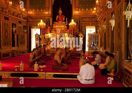 Thaïlande: Les moines chantent dans le viharn, Wat Ratchabophit, Bangkok.Wat Ratchabophit (Rajabophit) fut construit sous le règne du roi Chulalongkorn (Rama V, 1868-1910).Le temple mêle les styles architecturaux est et Ouest et est réputé pour son cloître circulaire entourant le grand chedi de style sri-lankais et reliant l'ubosot (bot) au nord avec le viharn au sud. Banque D'Images