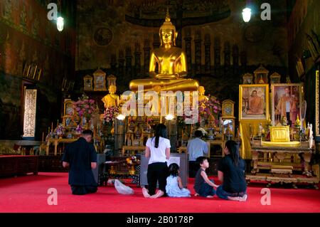 Thaïlande: Des dévotés dans le principal viharn, Wat Rakhang, Bangkok.Wat Rakhang Kositaram Woramahawihan (Rakang) a été construit à l'origine pendant la période Ayutthaya (1351 - 1767), mais a été rénové par le roi Bouddha Yodfa Chulaloke (Rama I, 20 mars 1736 – 7 septembre 1809), et se trouve sur le côté Thonburi de la rivière Chao Phraya de Bangkok.Rama J'ai vécu dans le complexe du temple avant qu'il ne devienne roi. Banque D'Images