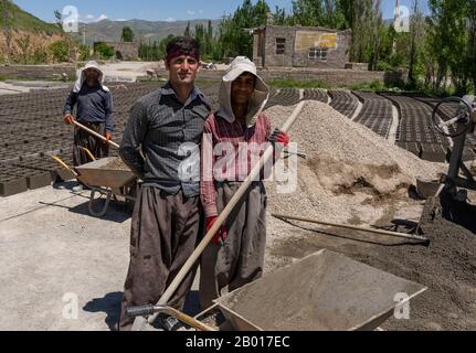 Shahin Dezh, Iran - 15 mai 2019: Trois travailleurs along la route en briques, Iran. Banque D'Images