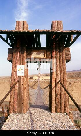 Chine : pont traversant la gorge de la rivière Taolai marquant la fin de la Grande Muraille de Ming près du fort de Jiayuguan. Jiayuguan, le «premier et plus grand passage sous le ciel», a été achevé en 1372 sur les ordres de Zhu Yuanzhang, le premier empereur Ming (1368-1398), à marquer la fin de la Grande Muraille de Ming. C’était aussi les limites mêmes de la civilisation chinoise et les débuts des terres «barbares» extérieures. Pendant des siècles, le fort n'était pas seulement d'importance stratégique pour les Chinois Han, mais aussi d'importance culturelle. C'était le dernier endroit civilisé avant l'obscurité. Banque D'Images