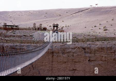 Chine : pont traversant la gorge de la rivière Taolai marquant la fin de la Grande Muraille de Ming près du fort de Jiayuguan. Jiayuguan, le «premier et plus grand passage sous le ciel», a été achevé en 1372 sur les ordres de Zhu Yuanzhang, le premier empereur Ming (1368-1398), à marquer la fin de la Grande Muraille de Ming. C’était aussi les limites mêmes de la civilisation chinoise et les débuts des terres «barbares» extérieures. Pendant des siècles, le fort n'était pas seulement d'importance stratégique pour les Chinois Han, mais aussi d'importance culturelle. C'était le dernier endroit civilisé avant l'obscurité. Banque D'Images