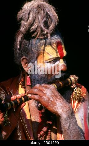 Népal: Pipe (flûte) jouant sadhu, Pashupatinath, Katmandou. Ils sont connus, varieusement, comme sadhus (saints, ou 'bons'), yogis (praticiens ascétiques), Fakirs (sébateur ascétique après la vérité) et sannyasins (mendiants errants et ascétiques errants). Ils sont les praticiens ascétiques – et souvent excentriques – d’une forme austère d’hindouisme. Juré de rejeter les désirs terrestres, certains choisissent de vivre comme anchorites dans le désert. D'autres sont moins à la retraite, en particulier dans les villes et les temples de la vallée de Katmandou au Népal. Banque D'Images