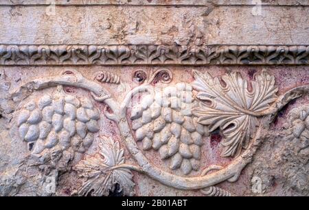 Syrie : raisins, relief de pierre, Temple de Bel, Palmyra. Palmyra était une ancienne ville de Syrie. C'était une ville importante dans le centre de la Syrie, située dans une oasis à 215 km au nord-est de Damas et à 180 km au sud-ouest de l'Euphrate à Deir ez-Zor. Elle a longtemps été une ville de caravane vitale pour les voyageurs traversant le désert syrien et était connue sous le nom de la mariée du désert. La référence la plus ancienne documentée à la ville par son nom sémitique Tadmor, Tadmur ou Tudmur (qui signifie 'la ville qui se repend' en Amorite et 'la ville indomitable' en araméen) est enregistrée dans les comprimés babyloniens trouvés à mari. Banque D'Images