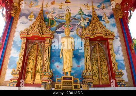 Thaïlande: Statue de Bouddha et peintures murales sur le viharn à Wat Phra Nang sang, Phuket. Wat Phra Nang sang a été fondé au 19th siècle par une dame locale de bonne famille, d'où le nom, phra nang sang, signifiant «construit par la dame vénérée». Son vrai nom semble avoir été oublié. Selon la tradition locale, elle s'est rendue au Sri Lanka pour un pèlerinage et, pour remercier son retour en toute sécurité, elle a parrainé la construction de ce temple. Plus tard, elle est tombée au scandale d'un dirigeant local qui a ordonné sa tête coupée, seulement pour trouver son sang coulait blanc avec pureté. Banque D'Images