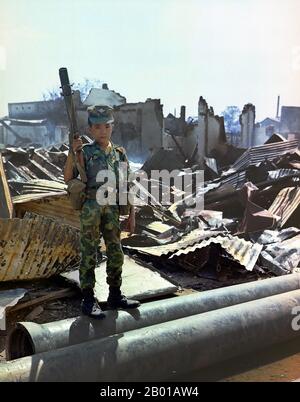 Vietnam : un enfant soldat de 12 ans dans l'uniforme de l'Armée de la République du Vietnam (ARVN), aéroport de Tan son Nhut, Saigon, 7 mai 1968. Un soldat vietnamien ARVN Airborne de douze ans qui avait été "adopté" par la division Airborne, tenant un lanceur de grenade M-79. La photo a été prise lors d'un balayage d'une unité de la Force opérationnelle aéroportée à travers la zone dévastée entourant le cimetière national français sur Plantation Road après une longue bataille là-bas. Banque D'Images