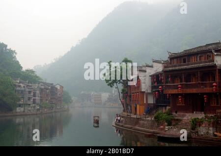 Chine : tôt le matin sur la rivière Tuo brumy de Fenghuang. Fenghuang est chinois pour Phoenix et se réfère à la mythique oiseau de feu sacré qui peut être trouvé dans les mythologies des Perses, Grecs, Romains, Egyptiens, Chinois, Et (selon Sanchuniathon) les Phéniciens. La légende suggère que deux phénolxes à la découverte de la ville ont survolé pendant un certain temps avant de voler à contrecœur. La ville de Fenghuang est une ancienne ville bien conservée qui remonte à 248 av. J.-C. Elle abrite les minorités Miao et Tujia. Banque D'Images