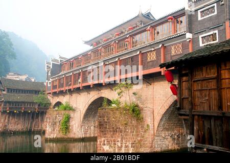 Chine : la brume surplombe le pont de Hong Qiao, le célèbre pont couvert de Fenghuang. Fenghuang est chinois pour Phoenix et se réfère à la mythique oiseau de feu sacré qui peut être trouvé dans les mythologies des Perses, Grecs, Romains, Egyptiens, Chinois, Et (selon Sanchuniathon) les Phéniciens. La légende suggère que deux phénolxes à la découverte de la ville ont survolé pendant un certain temps avant de voler à contrecœur. La ville de Fenghuang est une ancienne ville bien conservée qui remonte à 248 av. J.-C. Elle abrite les minorités Miao et Tujia. Banque D'Images