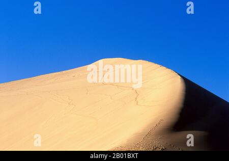 Chine : les dunes de sable chantant de Mingsha Shan (collines de Mingsha) dans le désert de Kumtagh, province de Gansu. Mingsha Shan (Singing Sand Dunes) sont situés à environ 4km au sud de Dunhuang. Ce sont les dunes de sable les plus grandes et les plus impressionnantes de Chine. Les dunes principales s'élèvent entre 250m et 300m. Ils sont appelés ‘Sablest’ parce que les grains de sable qui se déplacent font un bourdonnement dans les vents puissants. Le désert de Kumtagh est une section du désert de Taklamakan qui se trouve à l'est et au sud-est du désert de lop. Banque D'Images