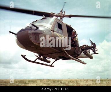 Vietnam : États-Unis Le Sgt Dennis Troxel de l'armée est assis sous le nom de « Hot fusil Rider » à la porte d'un hélicoptère Bell UH-1B Huey de la 179th Aviation Company, Vietnam, 1965. La deuxième guerre d'Indochine, connue en Amérique sous le nom de guerre du Vietnam, a été un conflit militaire de l'époque de la Guerre froide qui s'est produit au Vietnam, au Laos et au Cambodge du 1 novembre 1955 à la chute de Saigon le 30 avril 1975. Cette guerre a suivi la première Guerre d'Indochine et a été menée entre le Nord du Vietnam, soutenu par ses alliés communistes, et le gouvernement du Sud Vietnam, soutenu par les États-Unis et d'autres nations anticommunistes. Banque D'Images