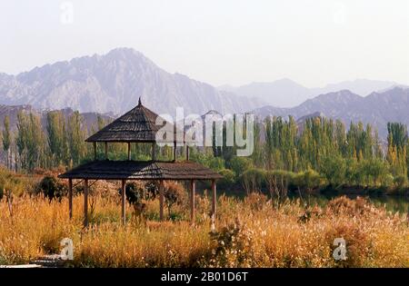 Chine : Pavillon près des grottes du Bouddha Kizil Thousand, Kuqa, province du Xinjiang. Les grottes de Kizil (Qizil Ming Oy; Kizil Cave of a Thousand Buddhas) sont 236 grottes bouddhistes coupées par roche situées près du canton de Kizil dans le Xinjiang. Le site est situé sur la rive nord de la rivière Muzat à 75 kilomètres par la route au nord-ouest de Kucha (Kuqa). Cette zone était un centre commercial de la route de la soie. On dit que les grottes sont le plus ancien complexe de grottes bouddhistes majeur du Xinjiang, avec un développement entre les 3rd et 8th siècles. Banque D'Images
