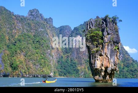 Thaïlande: Le bateau à longue queue passe Ko Tapu (île de Nail) à côté de Ko Khao Phing Kan (île James Bond), le parc national Ao Phang Nga (baie de Phangnga), province de Phang Nga. Inauguré en 1981, le parc national Ao Phang Nga couvre une superficie d'environ 400 km carrés et est composé principalement de rochers karstiques et d'îles, de falaises imposantes et des eaux claires de la mer de Phuket. Bien que abritant une grande variété de créatures marines et côtières, y compris le moniteur d'eau de deux mètres de long, la plupart des gens visitent le parc pour émerveiller et naviguer à travers et autour des nombreuses tours karstiques imminentes. Banque D'Images