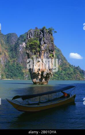 Thaïlande : Ko Tapu (île de Nail) et un bateau à longue queue de Ko Khao Phing Kan (île James Bond), parc national Ao Phang Nga (baie de Phangnga), province de Phang Nga. Inauguré en 1981, le parc national Ao Phang Nga couvre une superficie d'environ 400 km carrés et est composé principalement de rochers karstiques et d'îles, de falaises imposantes et des eaux claires de la mer de Phuket. Bien que abritant une grande variété de créatures marines et côtières, y compris le moniteur d'eau de deux mètres de long, la plupart des gens visitent le parc pour émerveiller et naviguer à travers et autour des nombreuses tours karstiques imminentes. Banque D'Images