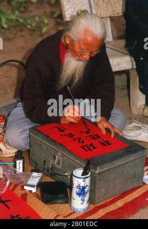 Vietnam : artiste de calligraphie avec une longue barbe blanche près du lac Ho Hoan Kiem, Hanoï. La calligraphie d'Asie de l'est est une forme de calligraphie largement pratiquée et vénérée dans la Sinosphère. Cela inclut le plus souvent la Chine, le Japon, la Corée et le Vietnam. La tradition calligraphique de l'Asie de l'est est originaire et développée de Chine. Il y a une normalisation générale des différents styles de calligraphie dans cette tradition. La calligraphie d'Asie de l'est et la peinture à l'encre et au lavage sont étroitement liées, depuis accompli en utilisant des outils et des techniques similaires. Banque D'Images