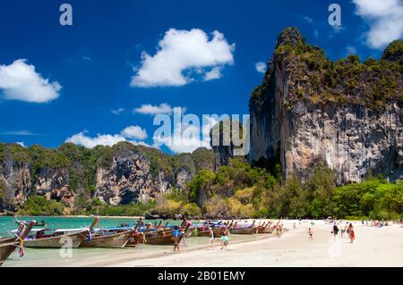 Thaïlande: Bateaux de visite alignés sur la plage, Hat Rai Leh West, Krabi Coast. Hat Rai Leh se divise en deux plages, à l'est et à l'ouest. Le premier, Rai Leh East, est assez boueux à marée basse, et les gens qui séjournent ici ont tendance à fréquenter Rai Leh West. Le chapeau Rai Leh West est plus sain et généralement plus attrayant. La province de Krabi est composée de plus de 5 000 km carrés de collines couvertes de jungle et de affleurements karstiques et déchiquetés, ainsi que de plus de 100km côtes luxuriantes et immaculées et d'environ 200 îles dans la mer voisine d'Andaman. Banque D'Images