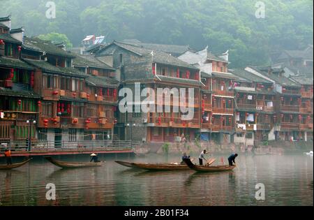 Chine: Des bateaux tôt le matin sur la rivière Túo brumeux de Fenghuang, Fenghuang, province de Hunan. Fenghuang est chinois pour Phoenix et se réfère à la mythique oiseau de feu sacré qui peut être trouvé dans les mythologies des Perses, Grecs, Romains, Egyptiens, Chinois, Et (selon Sanchuniathon) les Phéniciens. La légende suggère que deux phénolxes à la découverte de la ville ont survolé pendant un certain temps avant de voler à contrecœur. La ville de Fenghuang est une ancienne ville bien conservée, qui date soi-disant de 248 BCE. Elle abrite les minorités Miao et Tujia. Banque D'Images