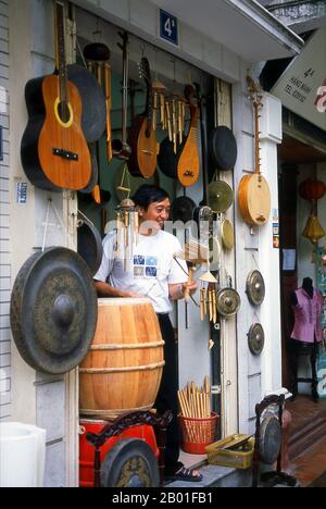 Vietnam: Instruments de musique à vendre dans le Vieux quartier, Hanoi. Le vieux quartier de Hanoi se trouve immédiatement au nord du lac Ho Hoan Kiem. Il est plus connu localement sous le nom de Bam Sau Pho Phuong ou les «trente six rues». 'Phuong' signifie une guilde commerciale, et la plupart des rues commencent par le mot 'Hang' signifiant marchandise. Cette partie ancienne de la ville a longtemps été associée au commerce, et elle le reste encore beaucoup aujourd'hui. Banque D'Images