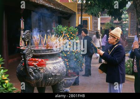 Vietnam : célébration du Tet (nouvel an vietnamien) à la Pagode Tran Quoc, Ho Tay (lac ouest), Hanoï. Le plus ancien temple de Hanoi, Chua Tran Quoc, se trouve sur une petite île juste à l'ouest de la chaussée à Ho Tay. Les origines précises de la pagode sont inconnues, mais selon la légende, elle a été établie à l'origine par les rives de la rivière Rouge sous le règne du roi Ly Nam de (544-548) dans un bref interrègne au cours du millénaire de l'occupation chinoise. La plus grande fête nationale du Vietnam est Tet – plus exactement, Tet Nguyen Dan, « Festival of the First Day » – qui coïncide avec le premier jour du nouvel an lunaire. Banque D'Images