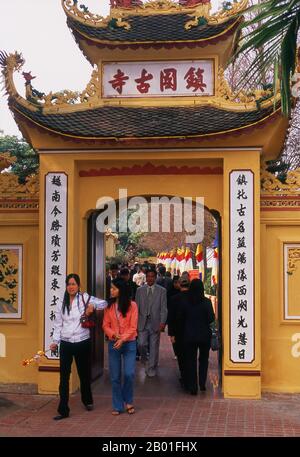 Vietnam: Tet (nouvel an vietnamien) célébrant à l'entrée de la Pagode Tran Quoc, Ho Tay, Hanoï. Le plus ancien temple de Hanoï, Chua Tran Quoc, se trouve sur une petite île juste à l'ouest de la chaussée à Ho Tay (lac de l'Ouest). Les origines précises de la pagode sont inconnues, mais selon la légende, elle a été établie à l'origine par les rives de la rivière Rouge sous le règne du roi Ly Nam de (544-548) dans un bref interrègne au cours du millénaire de l'occupation chinoise. La plus grande fête nationale du Vietnam est Tet – plus exactement, Tet Nguyen Dan, « Festival of the First Day » – qui coïncide avec le premier jour du nouvel an. Banque D'Images