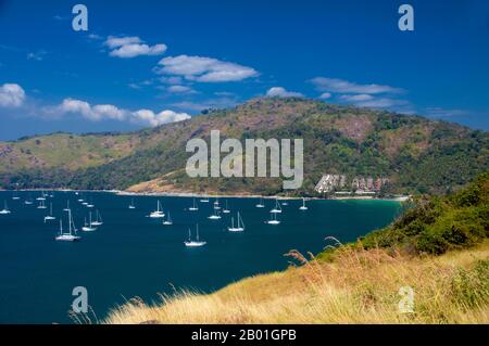 Thaïlande: Baie de nai Harn avec yachts et Phuket Yacht Club sur la colline, Hat Nai Harn, Phuket. Phuket, à 810sq km de la plus grande île de Thaïlande, se trouve dans la mer d'Andaman, au large de la province de Phang-nga. Rejoint au continent par une large chaussée, il s'est développé en la station balnéaire la plus luxueuse et la plus exquise de Thaïlande. Au cours des siècles passés, Phuket était un important poste de commerce sur la rive est de la baie du Bengale, manipulant la navigation et traitant avec des marins des mondes arabe et malais, de l'Inde, du Myanmar, de la Chine et, bien sûr, Siam. Banque D'Images