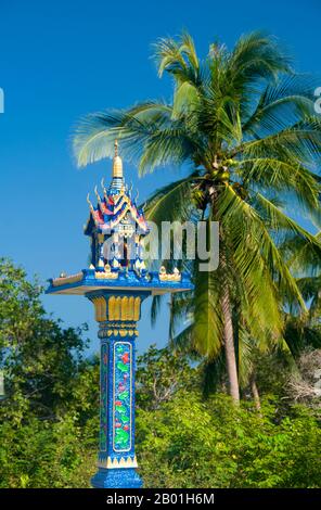 Thaïlande : un cocotier surplombe une maison d'esprit près de la plage à Ao Thong Nai Pan Yai, Ko Phangan. Beaucoup de thaïlandais croient que chaque maison devrait avoir sa propre maison d'esprit prévoyant le bien-être de l'esprit de la localité. Ceux-ci peuvent être n'importe où dans le jardin (même, dans les grandes villes, sur le toit), avec la condition importante que l'ombre de l'habitation humaine ne devrait jamais tomber sur la maison de l'esprit, la maison du propriétaire original et véritable de la terre - le chao thii. Naturellement, cette croyance s'étend aux magasins et au commerce aussi bien, avec un nary une entreprise en Thaïlande n'ayant pas au moins un. Banque D'Images