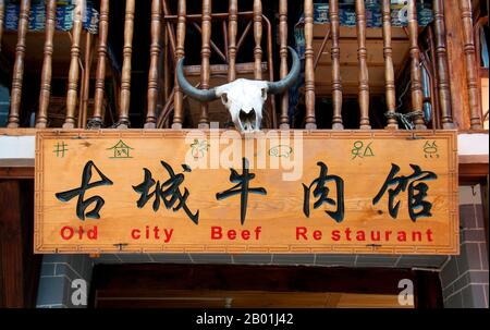 Chine : enseigne de restaurant affichant à la fois Naxi (Dongba) et l'écriture chinoise, vieille ville de Lijiang, province du Yunnan. Les Naxi ou Nakhi sont un groupe ethnique habitant les contreforts de l'Himalaya dans la partie nord-ouest de la province du Yunnan, ainsi que la partie sud-ouest de la province du Sichuan en Chine. On pense que les Naxi sont originaires du Tibet et, jusqu'à récemment, entretenaient des liens commerciaux terrestres avec Lhassa et l'Inde. Les Naxi forment l'un des 56 groupes ethniques officiellement reconnus par la République populaire de Chine. Les Naxi sont traditionnellement adeptes de la religion Dongba. Banque D'Images