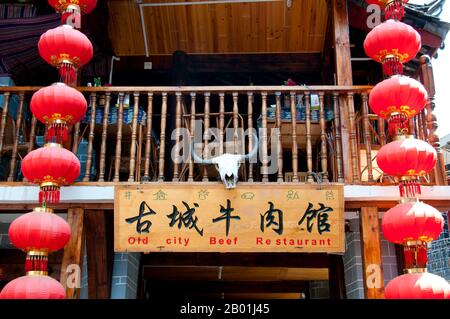 Chine : enseigne de restaurant affichant à la fois Naxi (Dongba) et l'écriture chinoise, vieille ville de Lijiang, province du Yunnan. Les Naxi ou Nakhi sont un groupe ethnique habitant les contreforts de l'Himalaya dans la partie nord-ouest de la province du Yunnan, ainsi que la partie sud-ouest de la province du Sichuan en Chine. On pense que les Naxi sont originaires du Tibet et, jusqu'à récemment, entretenaient des liens commerciaux terrestres avec Lhassa et l'Inde. Les Naxi forment l'un des 56 groupes ethniques officiellement reconnus par la République populaire de Chine. Les Naxi sont traditionnellement adeptes de la religion Dongba. Banque D'Images