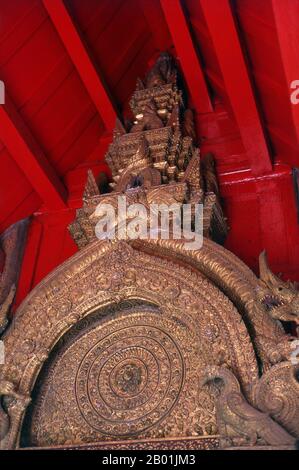 Thaïlande : un Dharmachakra ou 'roue de la Loi' au-dessus de l'entrée de Viharn Lai Kam, Wat Phra Singh, Chiang Mai, Nord de la Thaïlande. Le Dharmachakra (sanskrit : धर्मचक्र ; Pāli : Dhammacakka ; Tibétain : འཀོར་ལོ། (chos kyi 'khor lo) ; Chinois : 法輪 ; pinyin : fălún), lit. 'Roue du Dharma' ou 'roue de la Loi' est un symbole qui a représenté le dharma, l'enseignement du Bouddha sur le chemin de l'illumination, depuis les débuts du bouddhisme indien. Un symbole similaire est également utilisé dans le jaïnisme. C'est l'un des symboles Ashtamangala. Banque D'Images