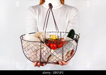 La femme garde le dos avec des légumes frais et des fuits dans des sacs textiles Banque D'Images