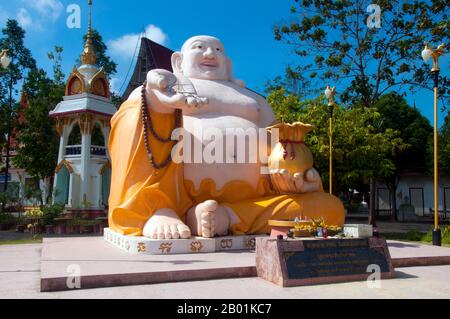 Thaïlande : la statue de Phra Sangkajjayana (Bouddha riant ou Budai), Wat Matchimaphum, ville de Trang, province de Trang, sud de la Thaïlande. Budai, prononcé Hotei en japonais et Bố Đại en vietnamien, est une divinité folklorique chinoise. Son nom signifie «sac en tissu» et vient du sac qu'il est classiquement représenté comme portant. Il est généralement identifié avec (ou comme une incarnation de) Bouddha Maitreya, à tel point que l'image Budai est l'une des principales formes dans lesquelles le Bouddha Maitreya est représenté en Asie de l'est. Il est presque toujours montré souriant ou riant, d'où son surnom chinois, le Bouddha riant Banque D'Images