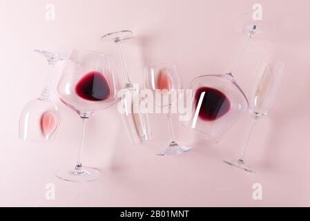 Assorted wineglasses de rouge, rose et vin blanc couché sur fond rose. Dégustation concept. Mise à plat. Vue d'en haut. Copy space Banque D'Images