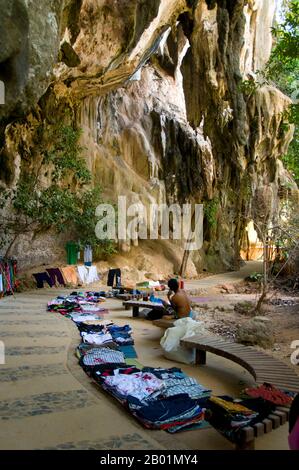 Thaïlande : vendeur de vêtements près de la grotte de Phra Nang, Tham Phra Nang, côte de Krabi. Tham Phra Nang ou la «Grotte de la Dame vénérée» est situé près de la pointe sud de l'étroite péninsule qui divise les plages de Rai Leh est et Rai Leh Ouest. Dédié à la mémoire d'une princesse indienne éponyme qui aurait été noyée au large il y a des siècles, un culte de la fertilité s'est développé autour de la grotte et un petit sanctuaire à l'intérieur. La grotte elle-même est remplie de phallus à pointe rouge placés ici par les pêcheurs dans l'espoir de bonnes prises ; de même, les femmes locales offrent des cadeaux si elles cherchent une grossesse. Banque D'Images