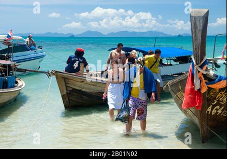 Thaïlande : les visiteurs arrivent à Hat Rai Leh West, côte de Krabi. Hat Rai Leh se divise en deux plages, est et Ouest. Le premier, Rai Leh East, est plutôt boueux à marée basse, et les gens séjournant ici ont tendance à fréquenter Rai Leh West. Hat Rai Leh West est plus sain et généralement plus attrayant. La province de Krabi est composée de plus de 5 000 km2 de collines couvertes de jungle et d'affleurements karstiques pointus et déchiquetés, ainsi que de plus de 100 km de côtes luxuriantes et immaculées et d'environ 200 îles dans la mer d'Andaman voisine. Banque D'Images