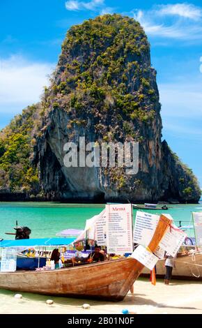 Thaïlande : bateaux d'excursion et bateaux de restauration alignés sur la plage de Hat Tham Phra Nang, côte de Krabi. Hat Tham Phra Nang, la «Plage de la Dame vénérée», est une belle plage de sable blanc à l'extrémité sud de la petite péninsule séparant Rai le East Beach de Rai Leh West Beach. La plage est considérée par beaucoup comme la plus belle de la région de Krabi, et aussi l'une des plus belles du sud de la Thaïlande. Composé de sable blanc et croquant et abrité par de hautes falaises de calcaire, le cadre idéal est rehaussé par des affleurements karstiques pointus et aux formes étranges. Banque D'Images