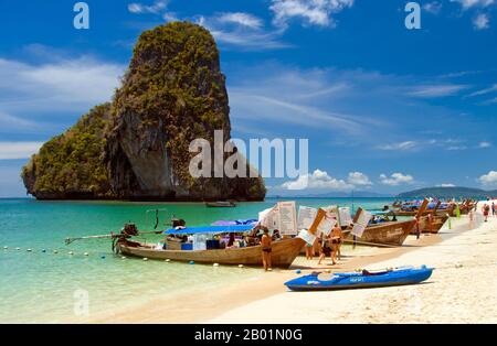 Thaïlande : bateaux d'excursion et bateaux de restauration alignés sur la plage de Hat Tham Phra Nang, côte de Krabi. Hat Tham Phra Nang, la «Plage de la Dame vénérée», est une belle plage de sable blanc à l'extrémité sud de la petite péninsule séparant Rai le East Beach de Rai Leh West Beach. La plage est considérée par beaucoup comme la plus belle de la région de Krabi, et aussi l'une des plus belles du sud de la Thaïlande. Composé de sable blanc et croquant et abrité par de hautes falaises de calcaire, le cadre idéal est rehaussé par des affleurements karstiques pointus et aux formes étranges. Banque D'Images