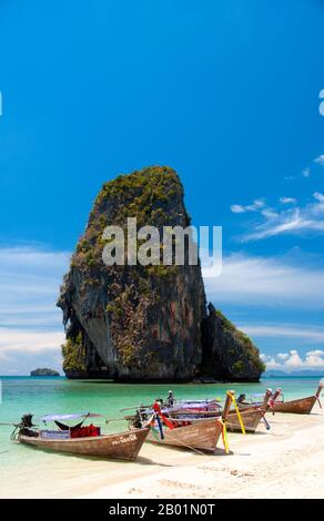 Thaïlande : bateaux d'excursion alignés sur la plage de Hat Tham Phra Nang, côte de Krabi. Hat Tham Phra Nang, la «Plage de la Dame vénérée», est une belle plage de sable blanc à l'extrémité sud de la petite péninsule séparant Rai le East Beach de Rai Leh West Beach. La plage est considérée par beaucoup comme la plus belle de la région de Krabi, et aussi l'une des plus belles du sud de la Thaïlande. Composé de sable blanc et croquant et abrité par de hautes falaises de calcaire, le cadre idéal est rehaussé par des affleurements karstiques pointus et aux formes étranges. Banque D'Images