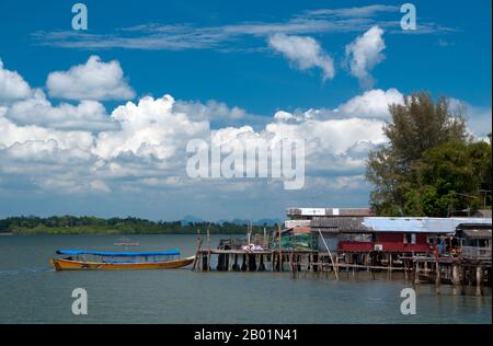 Thaïlande : maisons de pêcheurs sur pilotis à Ban Laem Kruat, point de ferry pour les îles de Ko si Boya et Ko Jam, côte de Krabi. La province de Krabi est composée de plus de 5 000 km2 de collines couvertes de jungle et d'affleurements karstiques pointus et déchiquetés, ainsi que de plus de 100 km de côtes luxuriantes et immaculées et d'environ 200 îles dans la mer d'Andaman voisine. Environ 40 % de la population provinciale est musulmane, le reste étant majoritairement bouddhiste. Ceci est une indication claire que Krabi se trouve à cheval sur la ligne de démarcation invisible entre la Thaïlande bouddhiste et les quatre provinces du sud. Banque D'Images