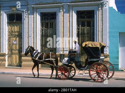 Cuba : voiture à cheval, Cardenas, province de Matanzas. Cárdenas, construite sur un quadrillage facile à suivre, est centrée sur la Catedral de la Immaculada Concepion (v. 1850), une belle église ancienne connue pour ses vitraux et devant laquelle se trouve une statue de Christophe Colomb sculptée par l'artiste espagnol Piquier en 1862. La ville a également un marché inhabituel en fonte appelé Plaza Molooff datant de 1859 avec un dôme de 16m (52.5ft) de haut. Cárdenas est connu pour les rangées de colonnades, maisons privées de plain-pied, la plupart peintes en pastels pâles et fanés et les grilles de fer élaborées sur les fenêtres. Banque D'Images