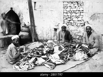 Égypte : fabricants de tapis au Caire. Photo des frères Adelphoi Zangaki/Zangaki, fin du XIXe siècle. Un tapis oriental authentique est un tapis fait à la main qui est noué avec du velours ou tissé sans velours. Par définition - les tapis orientaux sont des tapis qui viennent de l'Orient. La définition simple du terme serait - tapis qui viennent (ont été fabriqués dans) un pays asiatique comme : la Chine et le Vietnam à l'est à la Turquie, les pays du Maghreb, Chypre et l'Iran à l'ouest et le Caucase au nord à l'Inde au sud. Banque D'Images