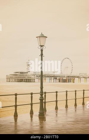 Image de style vintage de la plage néerlandaise avec une ancienne lanterne et des bâtiments à Scheveningen, aux Pays-Bas Banque D'Images
