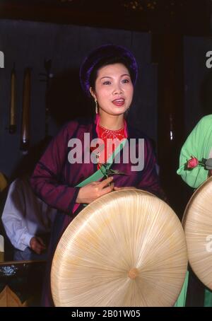 Vietnam : chanteuse avec un orchestre traditionnel vietnamien au Van Mieu (le Temple de la littérature), Hanoi. Le Vietnam a une longue tradition de musique et de théâtre qui combine influences indigènes et étrangères. Les premiers instruments connus sont les tambours de grenouille de la période Dong son à partir de 250 av. J.-C.. Cela a été suivi par un millénaire d'immersion dans les traditions culturelles chinoises qui reste très visible. En 981, après la réaffirmation de l'indépendance nationale, le roi le Dai Hanh envahit Champa voisin et ramène les danseurs et musiciens de la cour royale dans sa capitale. Banque D'Images