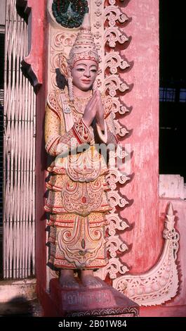 Birmanie/Myanmar : figure à l'entrée d'un petit sanctuaire dans le complexe de la pagode Shwedagon, Yangon (Rangoon). Le stupa doré de la pagode Shwedagon s'élève à près de 100 m (330 pieds) au-dessus de son cadre sur la colline de Singuttara et est plaqué de 8 688 dalles d'or massif. Ce stupa central est entouré de plus de 100 autres bâtiments, y compris de plus petits stupas et pavillons. La pagode était déjà bien établie lorsque Bagan dominait la Birmanie au XIe siècle. La reine Shinsawbu, qui a régné au XVe siècle, aurait donné à la pagode sa forme actuelle. Banque D'Images