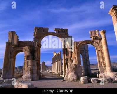 Syrie : entrée de la Grande Colonnade, Palmyre. Palmyre était une ancienne ville en Syrie. C’était une ville importante du centre de la Syrie, située dans une oasis à 215 km au nord-est de Damas et à 180 km au sud-ouest de l’Euphrate à Deir ez-Zor. Elle avait longtemps été une ville caravane vitale pour les voyageurs traversant le désert syrien et était connue comme la mariée du désert. La plus ancienne référence documentée à la ville par son nom sémitique Tadmor, Tadmur ou Tudmur (qui signifie «la ville qui repousse» en Amoréen et «la ville indomptable» en araméen) est enregistrée dans les tablettes babyloniennes trouvées à mari. Banque D'Images