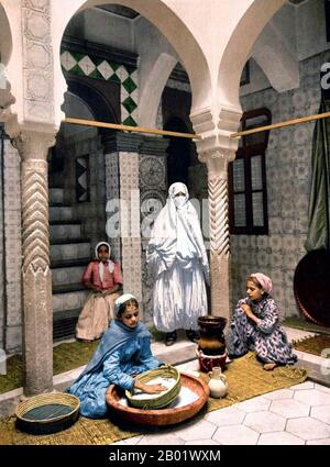 Algérie : 'femmes Maures' (femmes mauresques), femmes préparant du couscous dans une cour d'Alger. Photographie de Luce Ben Aben, 1899. L'histoire d'Alger de 1815 à 1962 est liée à l'histoire plus large de l'Algérie et de ses relations avec la France. Le 4 juillet 1830, sous prétexte d'un affront au consul français - que le dey avait frappé avec un fouet à mouche lorsque le consul déclarait que le gouvernement français n'était pas prêt à payer ses dettes importantes à deux marchands algériens - une armée française dirigée par le général de Bourmont attaqua la ville lors de l'invasion d'Alger en 1830. Banque D'Images