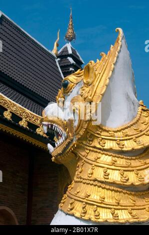 Thaïlande : les lions gardiens (Singha ou Chinthe) et le nouveau viharn à Wat Yang Kuang, Suriyawong Road, Chiang mai, dans le nord de la Thaïlande. Wat Yang Kuang, Suriyawong Road, Chiang mai a une longue histoire en damier. Initialement mentionné dans le Nirat Haripunchai (1517) sous le nom de Wat Nang Rua, il a été abandonné à la suite des guerres destructrices du XVIIIe siècle avec la Birmanie, conduisant à l'abandon de la ville de Chiang mai entre 1775 et 1797 sur instruction de Chao Kawila. Banque D'Images