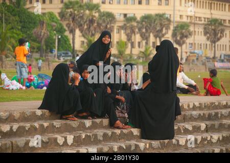 Sri Lanka : étudiants musulmans à Galle face au coucher du soleil, Colombo. Il y a des musulmans au Sri Lanka depuis plus de mille ans. Le commerce des boudins parcourait les eaux entre le moyen-Orient et l'île connue des marins arabes - comme Sinbad - sous le nom de Serendib même à l'époque pré-islamique. Les premiers marchands et marins musulmans ont peut-être débarqué sur ses rives pendant la vie de Mahomet. Au Xe siècle, cette communauté majoritairement arabe avait acquis une influence suffisante pour contrôler le commerce des ports du sud-ouest, tandis que les rois cinghalais employaient généralement des ministres musulmans pour diriger les affaires commerciales. Banque D'Images