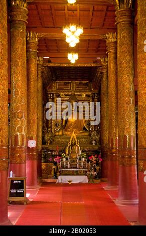 Thaïlande : figure de Bouddha dans le vieux Viharn, Wat Hang Dong, Chiang mai, nord de la Thaïlande. Wat Hang Dong est un exemple typique de l'architecture traditionnelle du temple LAN Na. Le vieux viharn de ce temple est un peu plus élaboré que son homologue à proximité de Wat ton Kwen, mais il est essentiellement similaire dans la forme, le style et l'apparence. Aussi sombre et intime, avec un toit bas et large à trois niveaux, le viharn abrite une collection d'images de Bouddha, dont au moins deux - à droite et à gauche de l'image principale de Bouddha - sont distinctement lao dans le style et pourtant étrangement primitifs. Banque D'Images