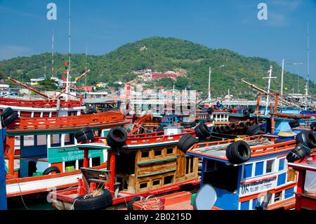 Thaïlande : bateaux de pêche dans le port avec le temple chinois San Chao Paw Khao Yai en arrière-plan, Ko Sichang, province de Chonburi. Mystère entoure ce temple chinois coloré à plusieurs niveaux avec certains historiens disant qu'il remonte à la dynastie chinoise Ming (1368-1644). Il est communément admis qu'un sanctuaire a été fondé sur ce site par des marins chinois après qu'ils ont repéré une lumière réfléchie d'une grotte, qu'ils ont utilisé comme phare de fortune pour la navigation. Le temple a été construit quelque temps plus tard, principalement à l'usage des pèlerins chinois. Banque D'Images