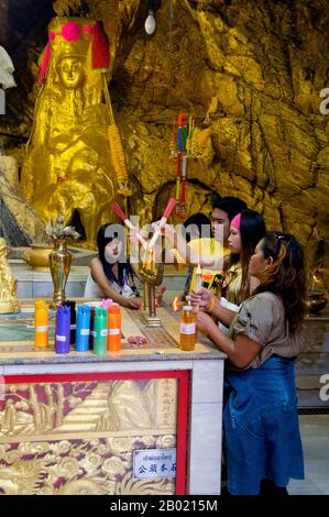 Thaïlande : les visiteurs de Bangkok éclairent de l'encens dans les grottes du sanctuaire du temple chinois San Chao Paw Khao Yai, Ko Sichang, province de Chonburi. Mystère entoure ce temple chinois coloré à plusieurs niveaux avec certains historiens disant qu'il remonte à la dynastie chinoise Ming (1368-1644). Il est communément admis qu'un sanctuaire a été fondé sur ce site par des marins chinois après qu'ils ont repéré une lumière réfléchie d'une grotte, qu'ils ont utilisé comme phare de fortune pour la navigation. Le temple a été construit quelque temps plus tard, principalement à l'usage des pèlerins chinois. Banque D'Images